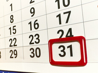 Close-up of a calendar with the date 31 highlighted in a red frame. This is the last day of the month, surrounded by other numbers.