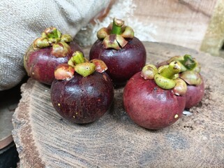 Fresh mangosteen fruit arranged on a wooden table