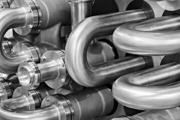 A close up of a group of metal pipes as industrial background. pipes are silver and have a shiny...