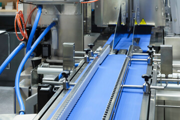 Fragment of the conveyor of sticking labeling machine. Abstract industrial background.