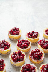 Mini cheesecake with cherry jam. One bite dessert. Tiny cheesecakes with berry. Valentine homemade present. Selective focus.