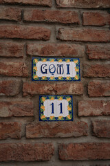 The plaque on the house is made of ceramic tiles. The license plate on the house. The address plate...