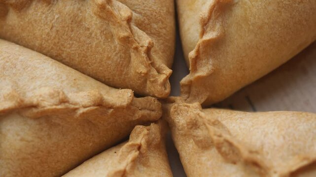 corners of fresh hot pastries with fillings and pies made by hand by a chef from dough. triangular pies. Tatar cuisine. Uchpuchmak. Top view.