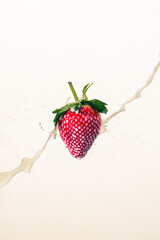Still of a strawberry splashed with milk