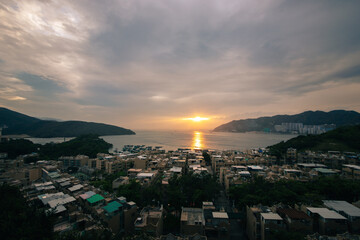 Tranquil scene of a historic Hong Kong village bathed in the warm glow of the setting sun. Peaceful and serene atmosphere.