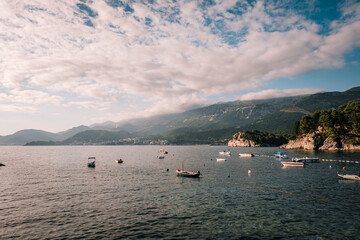 Scenic view of the Becici coastline in Montenegro.  Turquoise waters of the Adriatic Sea meet the sandy beach, with mountains in the background.  Summer vacation destination.