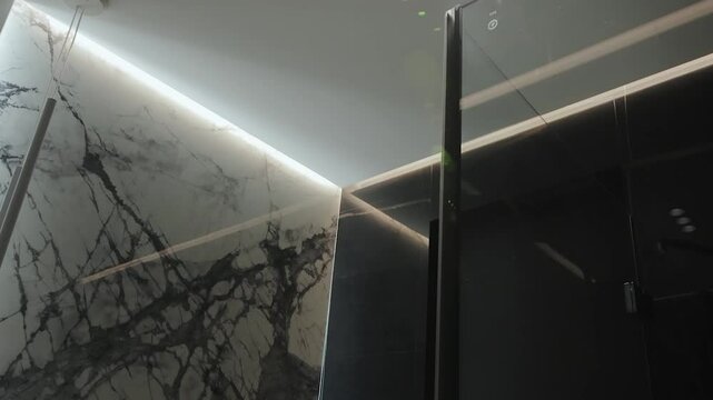 Close-up of a modern bathroom ceiling with a stunning black marble backsplash and great lighting