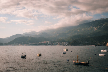 Scenic view of the Becici coastline in Montenegro.  Turquoise waters of the Adriatic Sea meet the sandy beach, with mountains in the background.  Summer vacation destination.