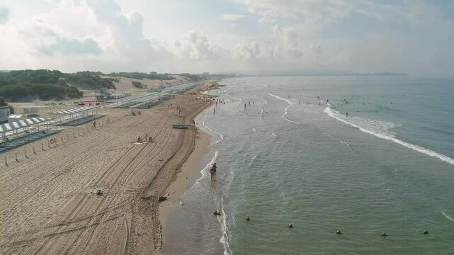 Beach with people in the water and a boat in the water. Scene is relaxed and peaceful. The Black Sea coast in Anapa at the height of the summer season.
