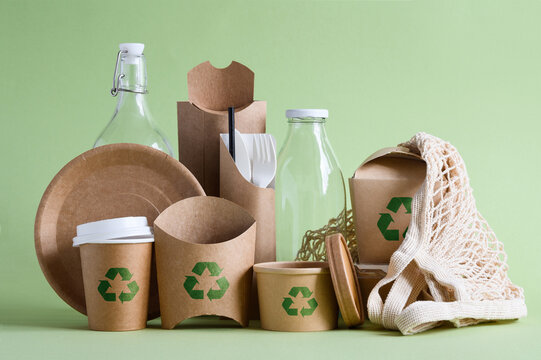 Paper eco food packaging with recycling sign on green background. Zero waste concept