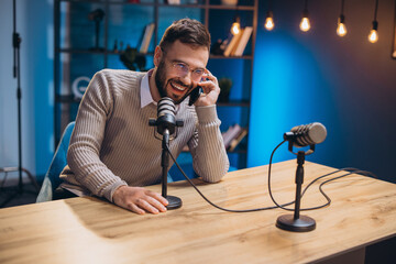 Energetic podcaster speaking into microphone during recording session, capturing professional audio...