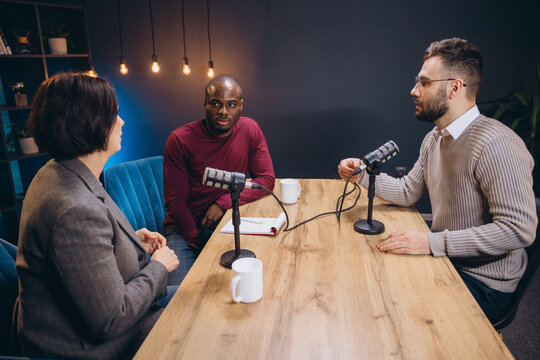 Content creators recording an interview in a studio, using professional microphones and equipment