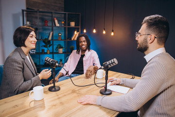 Content creators recording a new podcast episode, discussing and sharing their ideas with microphones in a professional studio