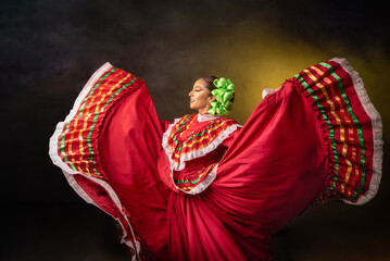 A woman in a red dress is dancing with a green flower in her hair