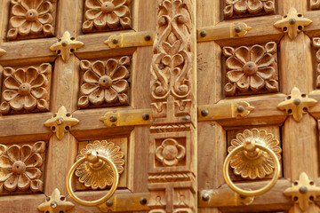 Ornate wooden door with carved patterns and golden handles in Jodhpur, India