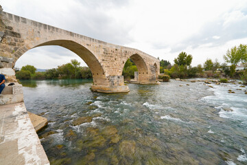 Seljuk bridge in Aspendos. The Eurymedon Bridge. Aspendos Yolu Belkis Mevkii. Turkey. Crooked bridge. Bridge over the Koprucay (Euremedon) River near Aspendos, in Pamphylia, in southern Anatolia 