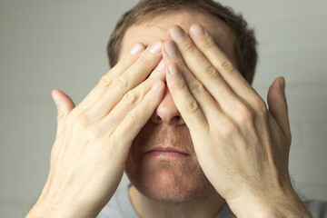 Fototapeta premium man applies cosmetic serum or face cream to his facial skin, skin care concept