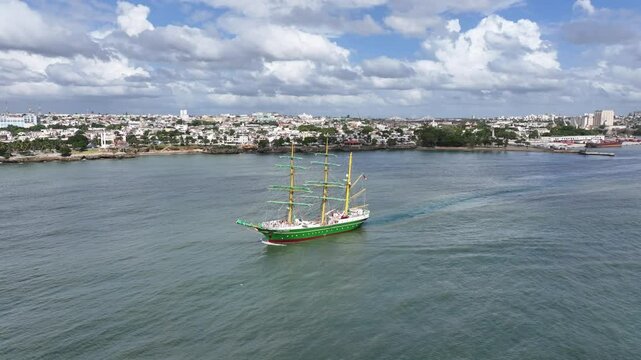 Santo Domingo, Dominican Republic, aerial video footage of three masted square rigger "Alexander von Humboldt 2", a German sailing ship, leaving the port, city Santo Domingo in background  