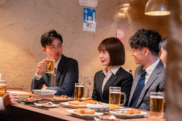 居酒屋で新入社員の歓迎会をするビジネスパーソン