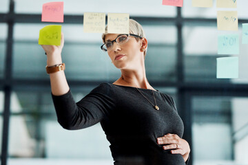 Glass wall, planning and pregnant woman in office with research for project with information. Brainstorming, pregnancy and female creative director writing notes on board for campaign in workplace.