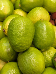 Fresh limes gathered together in vibrant green hues at a local market