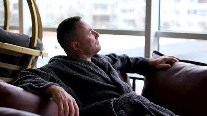 hamam man 48 year old Brazilian man wearing a robe and drinking a cup of tea and smiling at the camera.