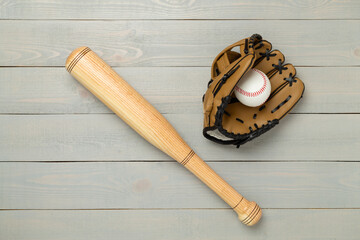 Baseball glove and bat with ball on wooden background, top view