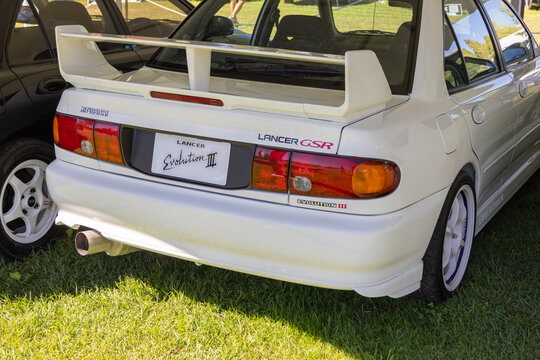 White mitsubishi lancer evolution iii gsr parked on grass