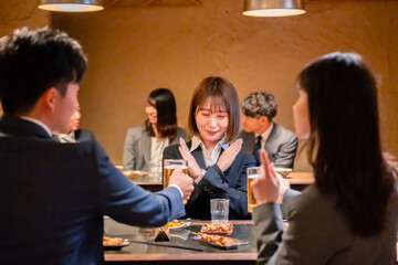 居酒屋で新入社員の歓迎会をするビジネスパーソン