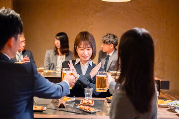 居酒屋で新入社員の歓迎会をするビジネスパーソン