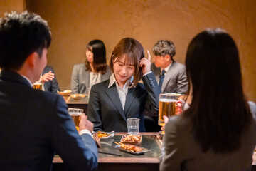 居酒屋で新入社員の歓迎会をするビジネスパーソン