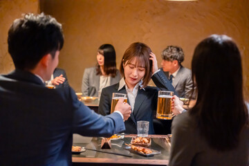 居酒屋で新入社員の歓迎会をするビジネスパーソン