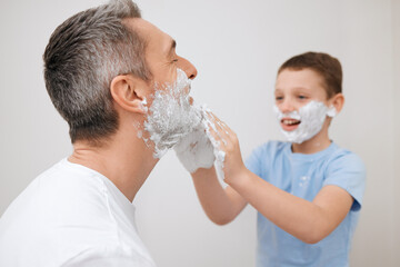 Shaving, father and child with cream in studio for grooming, skincare lesson and product...