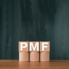 There is wood cube with the word PMF. It is an abbreviation for Product Market Fit as eye-catching...