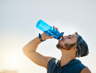 Man, runner and drinking water with fitness, outdoor and hydration for wellness at training in...