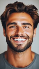 Obraz premium A vibrant portrait of a young man radiating joy with a bright smile, showcasing his charming facial features and stylish hairstyle, reflecting happiness and confidence.
