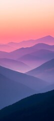 A close-up of a mountain range at sunrise with the peaks illuminated in shades of pink and orange