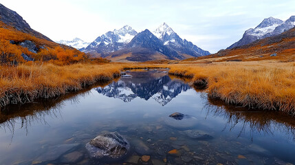 Fototapeta premium Snow-capped mountains reflect in a calm river flowing through a golden autumn valley under a cloudy sky.
