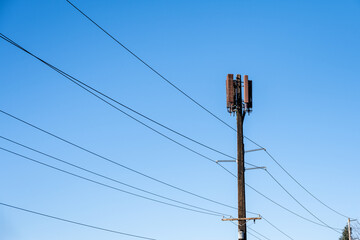 Wireless communications cell site, mobile phones, collocated on a wood glue laminate power line...