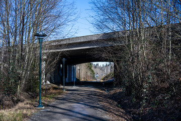 Cross Kirkland Corridor Trail crossing under highway I405 overpass on a sunny winter day, outdoor...