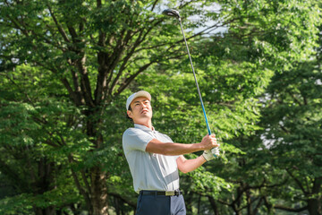 ゴルフ場でゴルフをするゴルファーの男性(ティーショット・ゴルフコンペ)
