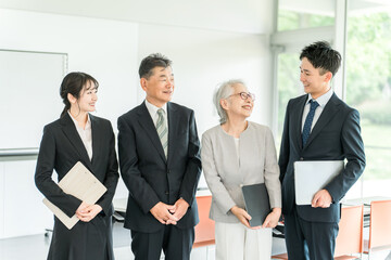 スーツ姿の高齢者・シニアと若者（M&A・後継者・事業継承・跡取り・売却・買収・世代交代）
