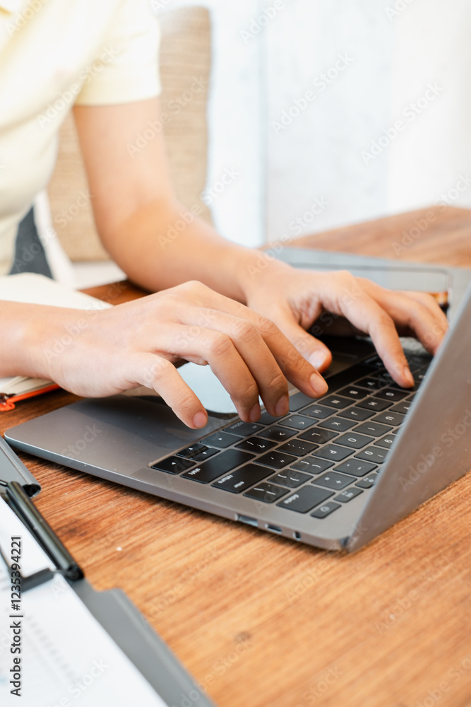 Poster hands typing on a laptop in a modern workspace. focus on fingers and keyboard.