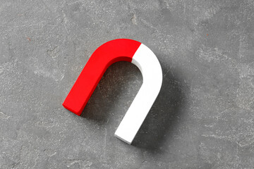One horseshoe magnet on grey textured background, top view