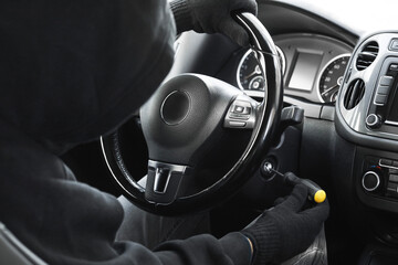 Thief trying to start ignition switch with screwdriver, closeup. Car hijacking