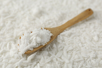 White soy wax flakes and spoon, closeup