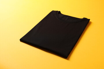 Blank black t-shirt on yellow background. Mockup for design