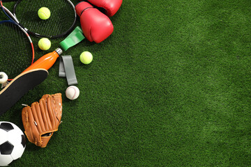 Different sport equipment on artificial grass, flat lay. Space for text