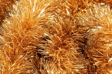 Shiny golden tinsel as background, closeup view