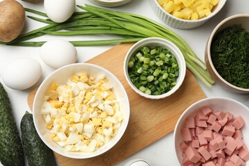 Different ingredients for okroshka soup on white table, flat lay